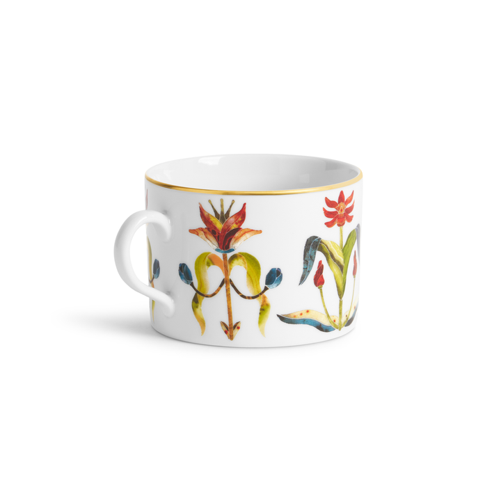 A white teacup with painted floral designs and a gold rim