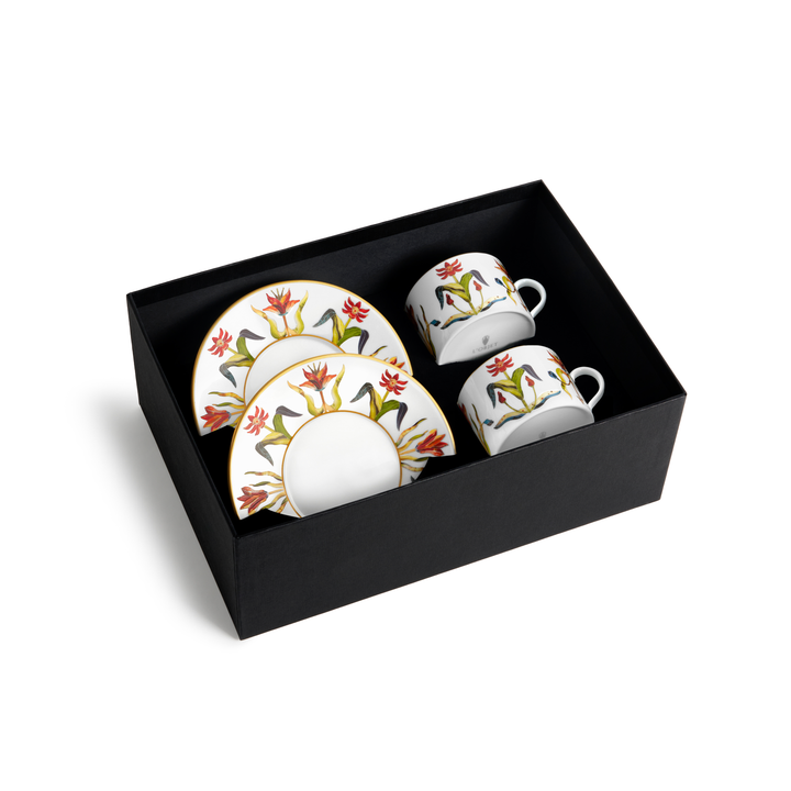 Two gold rimmed white floral painted cups with matching saucers in a black box
