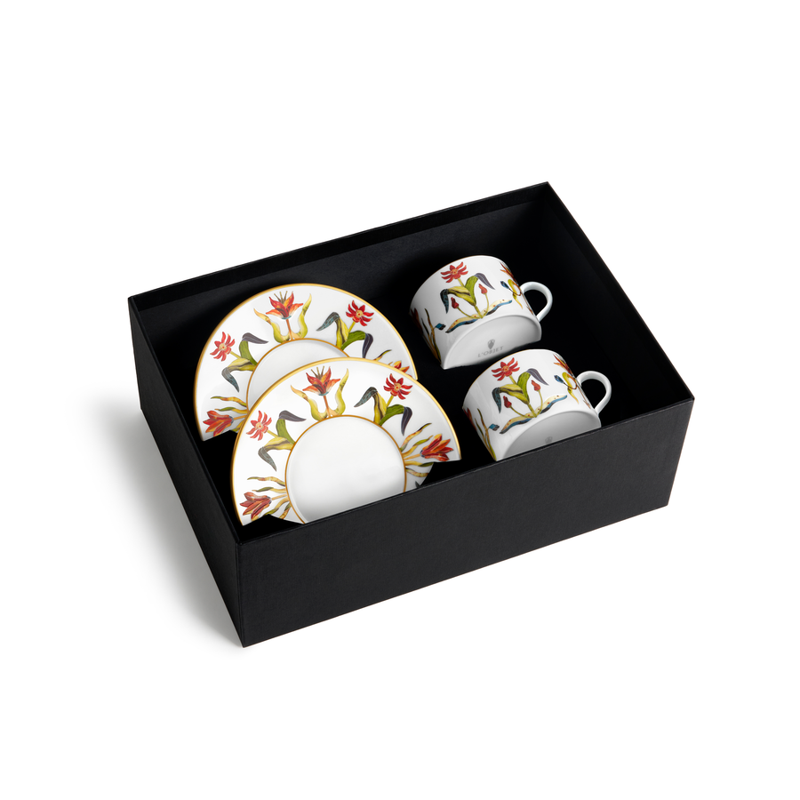 Two gold rimmed white floral painted cups with matching saucers in a black box