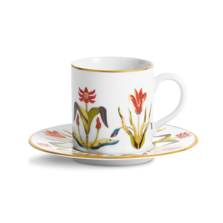 A White porcelain teacup and saucer with floral painted patterns and a gold rim