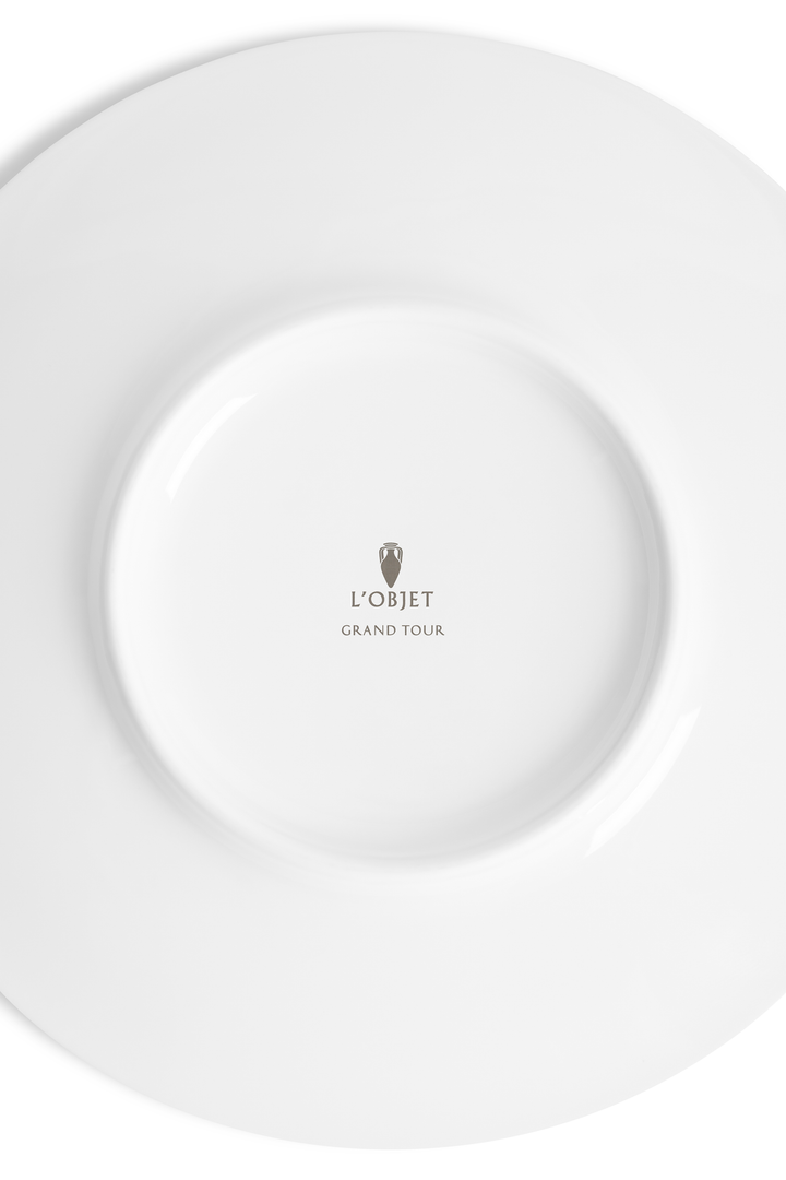 The white underside of a dish with the L'Objet logo and the words "grand tour" inscribed
