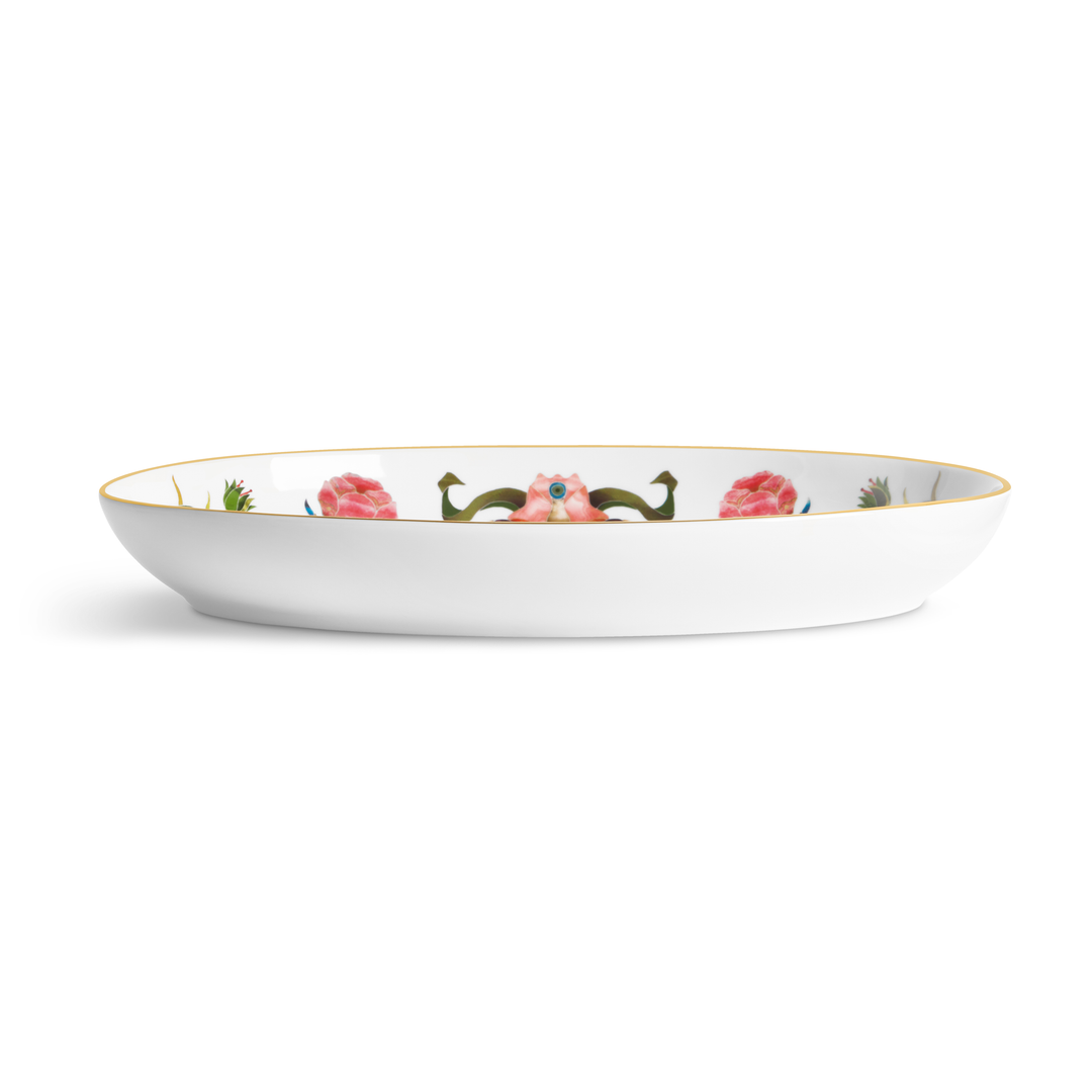 A white porcelain dish with floral painted designs on the inside and a gold rim