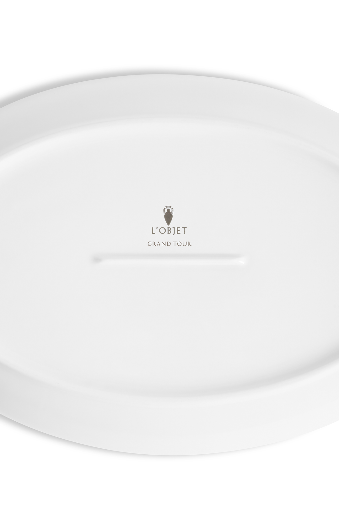 The bottom of a porcelain saucer with the L'Objet logo and "grand tour" imprinted 