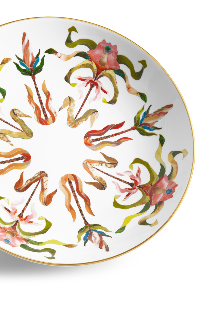A white porcelain saucer with a gold rim and painted floral motifs
