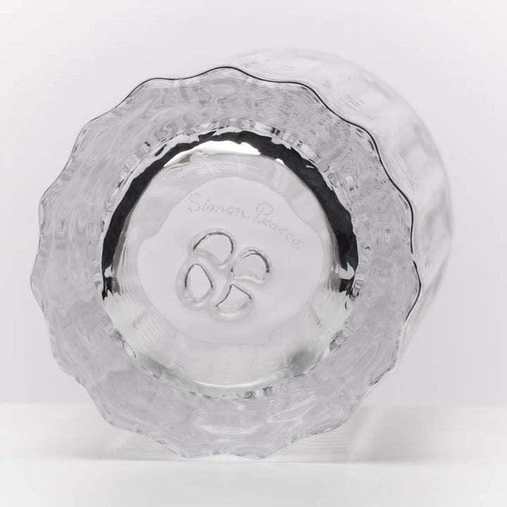 A clear textured glass bowl with a scalloped rim, photographed from a top-down angle on a white background. The brand name 'Simon Pearce' is etched in the center.