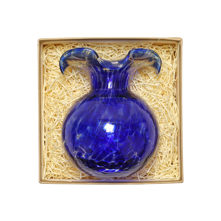 Blue glass vase in a decorative box with straw padding