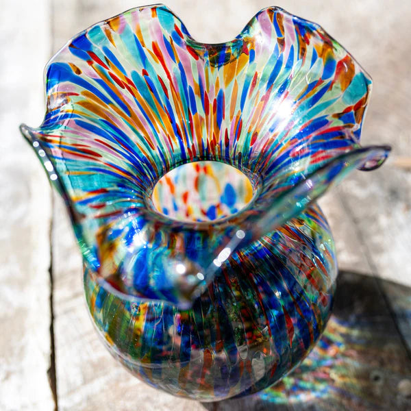 Multicolored glass vase on a wooden surface