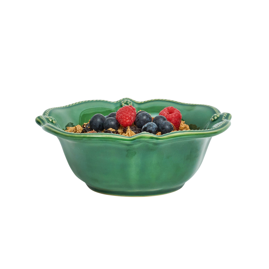 Green ceramic bowl with berries and on a white background