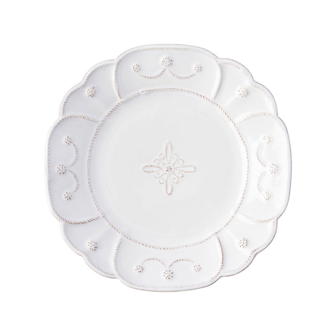 A small plate with floral threaded designs around the edged and a thread motif in he middle