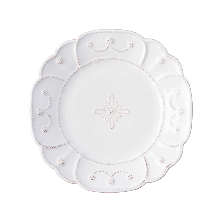 A small plate with floral threaded designs around the edged and a thread motif in he middle