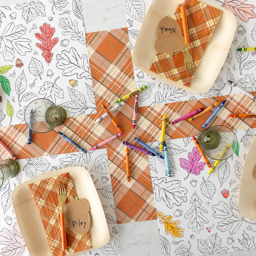 Coloring book pages with autumn-themed designs and crayons on a table.