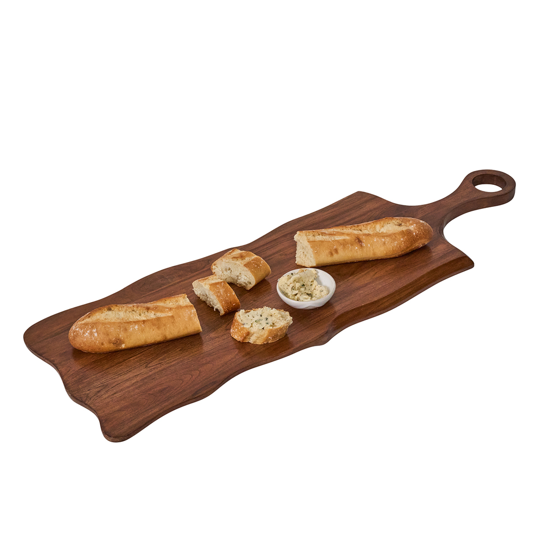 Wooden serving board with bread and a small bowl of spread on a white background