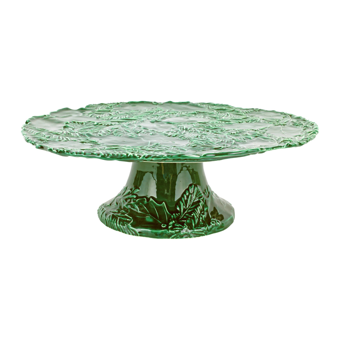 Green ceramic cake stand with holly design on a white background