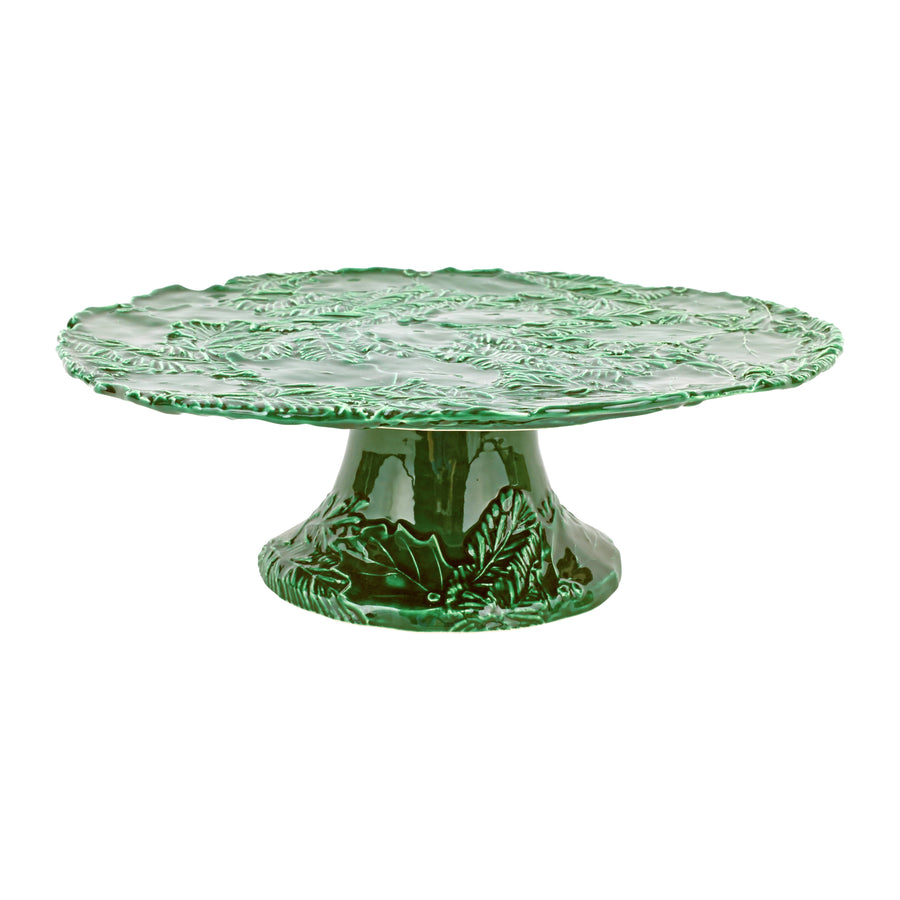Green ceramic cake stand with holly design on a white background