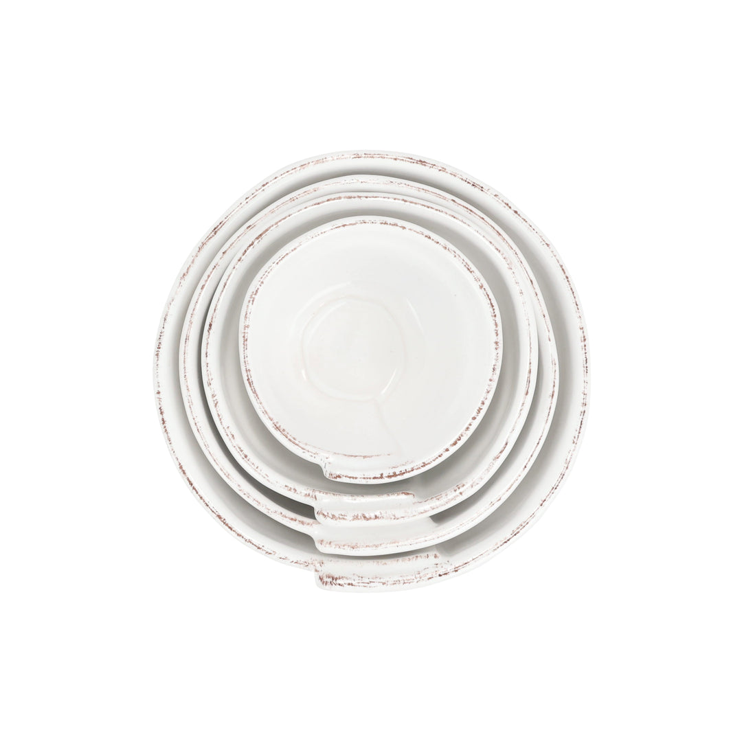 Set of four white ceramic plates with a distressed finish on a white background