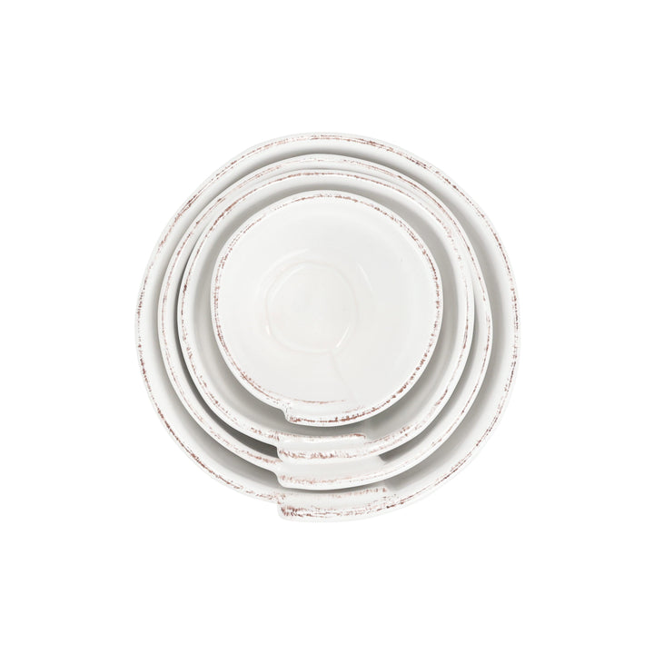 Set of four white ceramic plates with a distressed finish on a white background