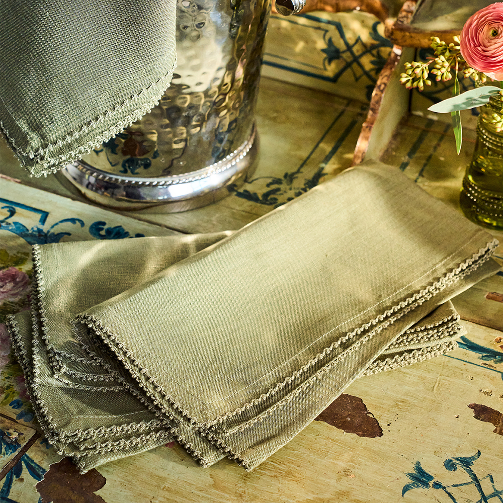 Stack of green napkins on a decorative table with floral elements