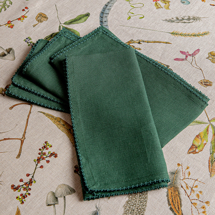 Stack of green napkins on a patterned fabric background