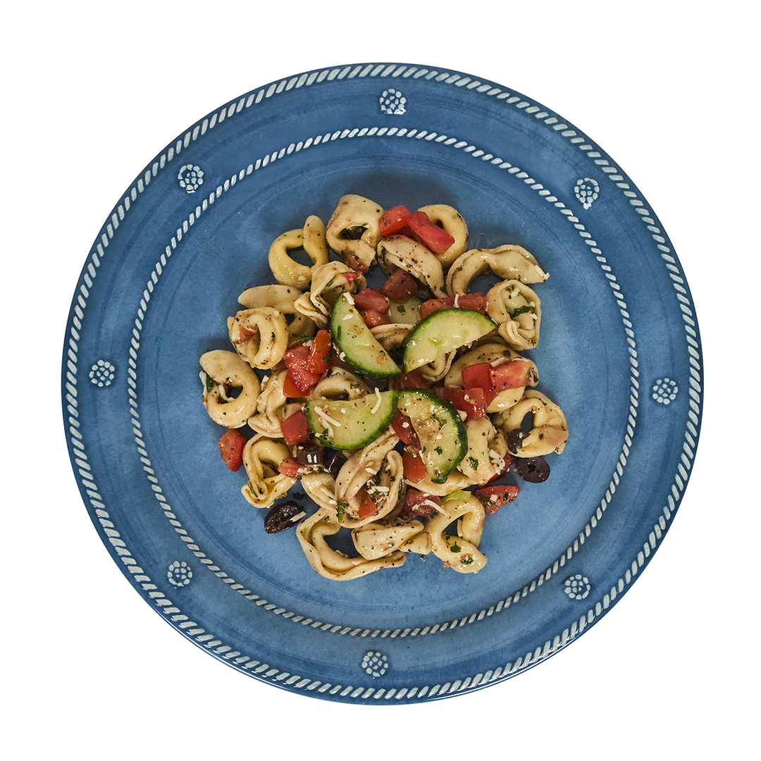 Blue plate with pasta dish featuring vegetables