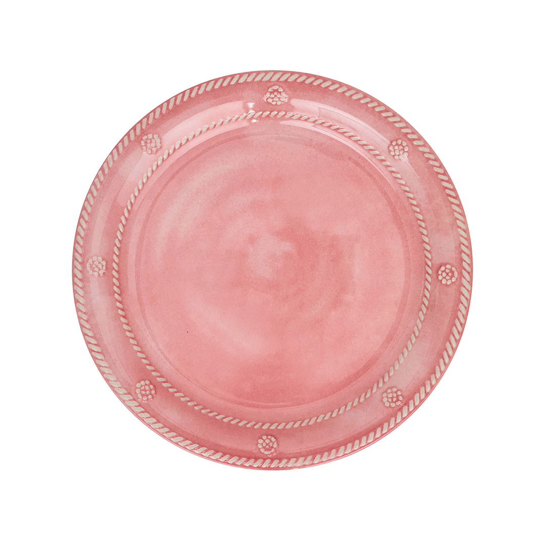 A round pink ceramic plate with a decorative rope border and small floral motifs
