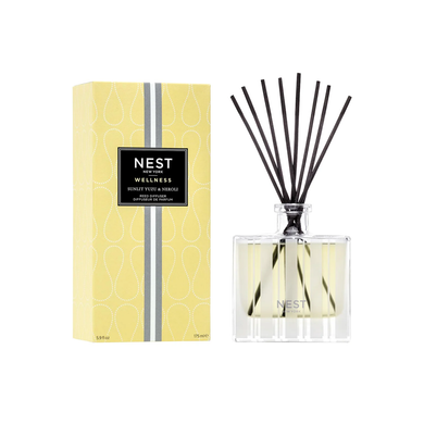A Nest Brand reed diffuser sitting next to a box reading Nest New York Wellness