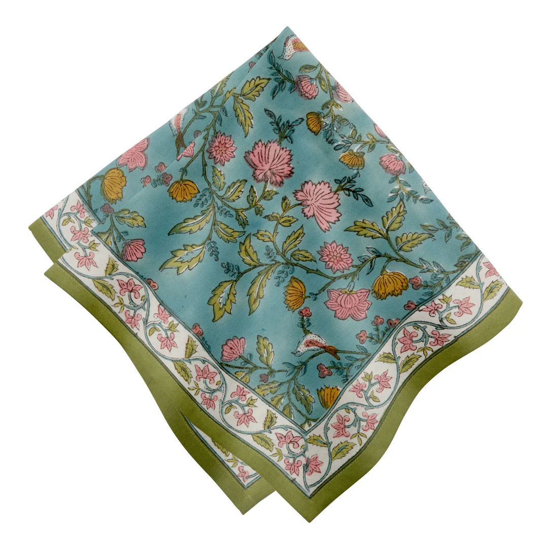 A blue napkine with green trim and pink and orange flower patterns
