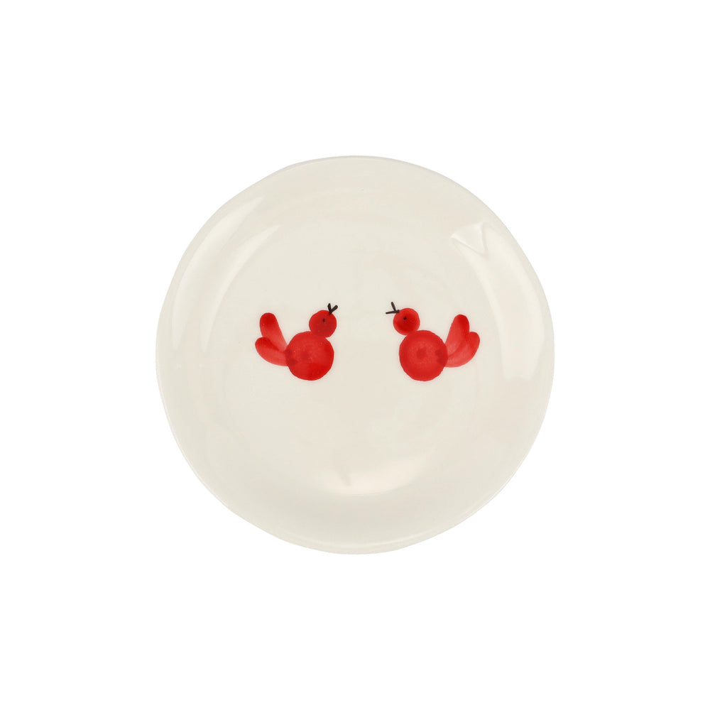 White plate with two red birds painted on it
