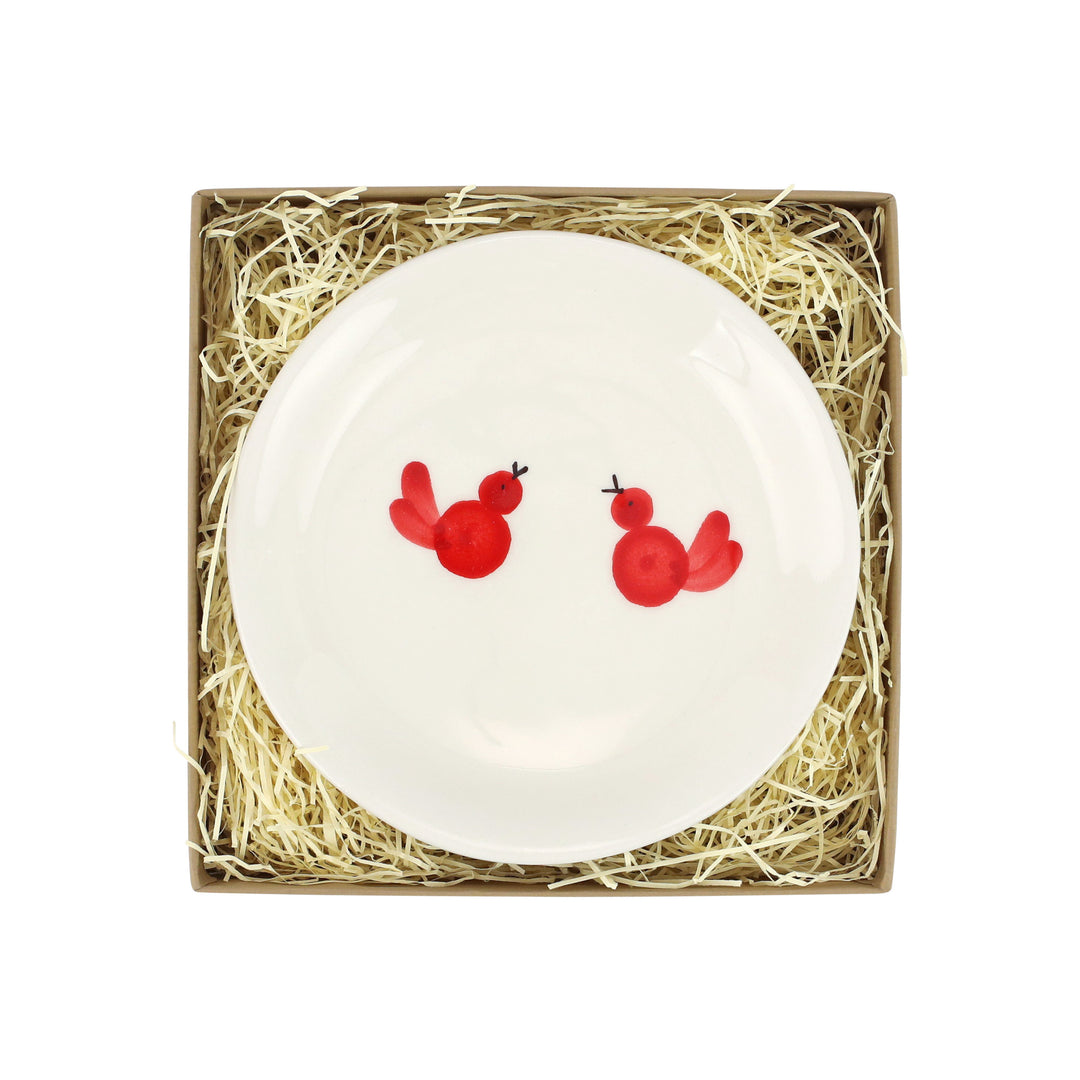 White plate with two red birds painted on it
