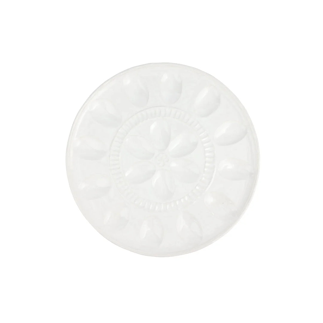 A round white ceramic plate with a raised floral pattern in the center and petal-like indentations around the rim, shown on a plain white background.
