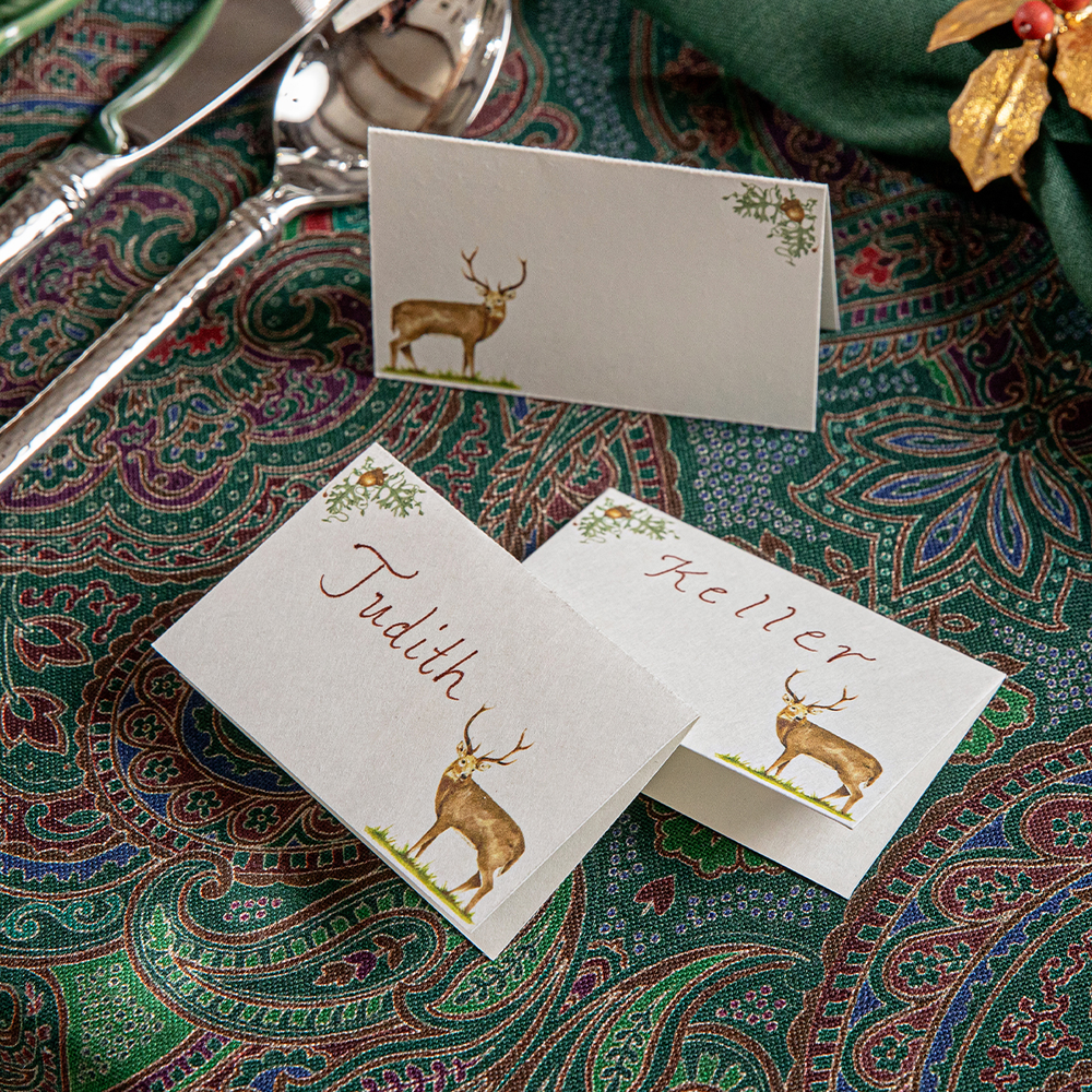 Name cards with deer illustration on a patterned tablecloth