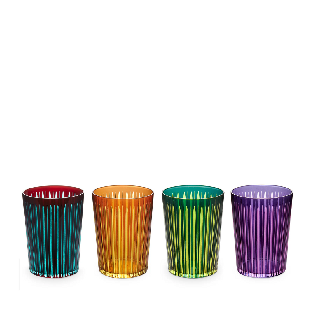 Four colorful glass tumblers with vertical cut glass stripes on a white background