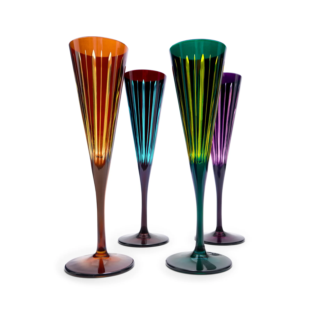 Set of four multicolored glass flutes on a white background