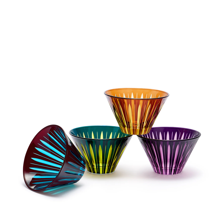 Set of four colorful glass condiment bowls stacked on a white background