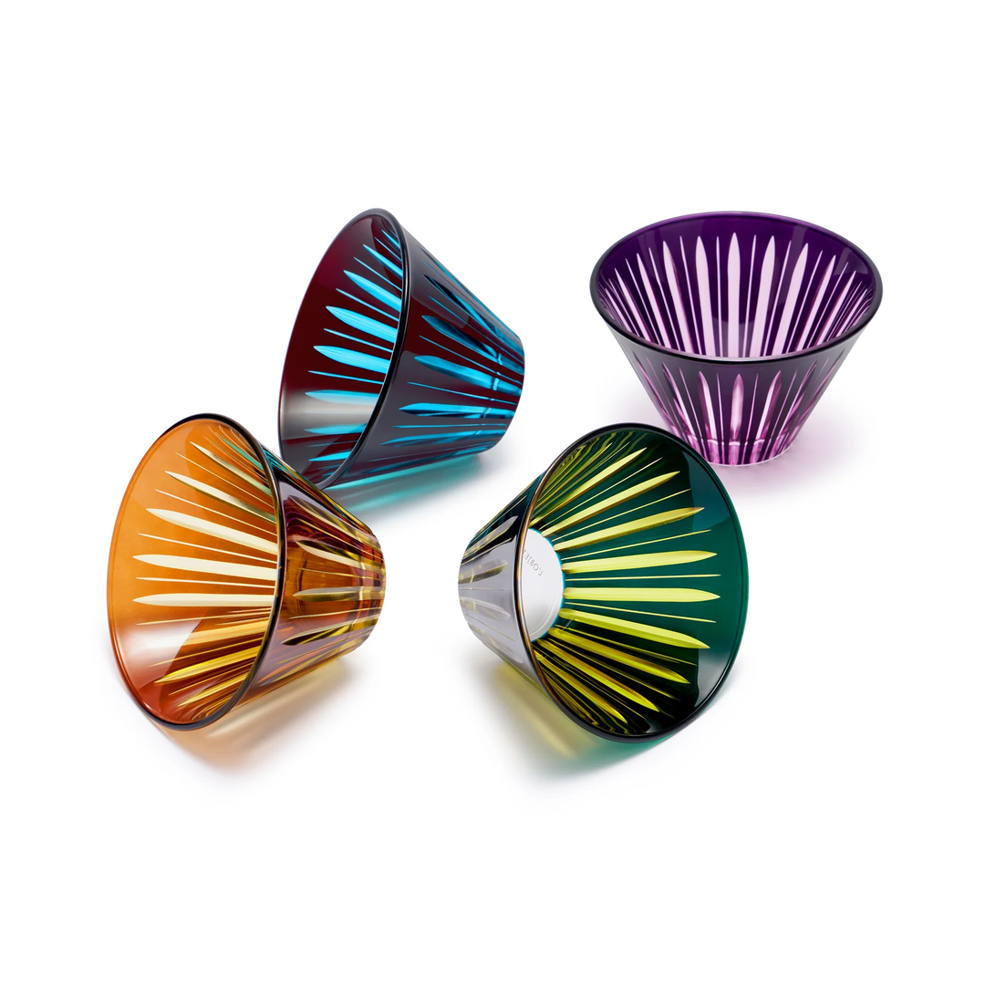 Four colorful glass condiment cups with striped patterns on a white background