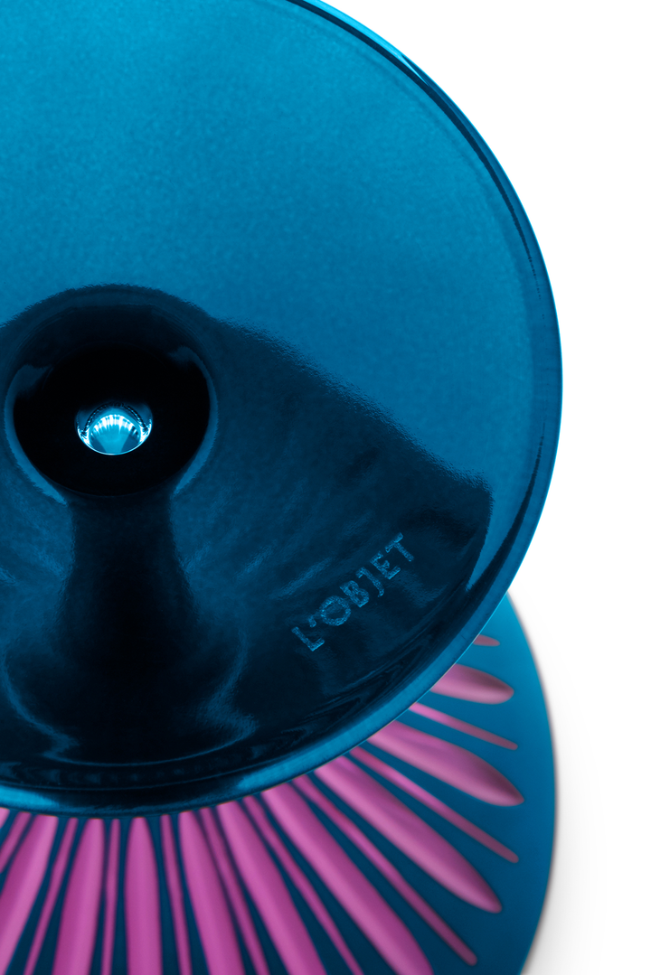 CLose up of the bottom of a blue and pink martini glass etched with the l'objet logo