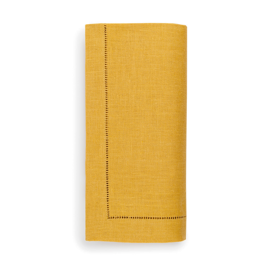 Mustard yellow napkin with a stiched border on a white background