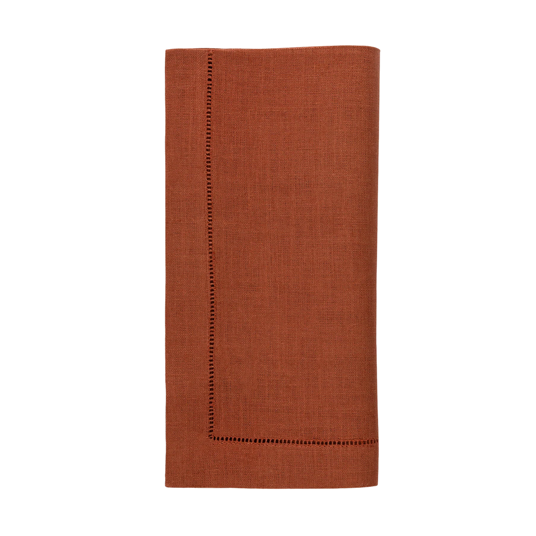 paprika reddish brown napkin with a decorative hem on a white background