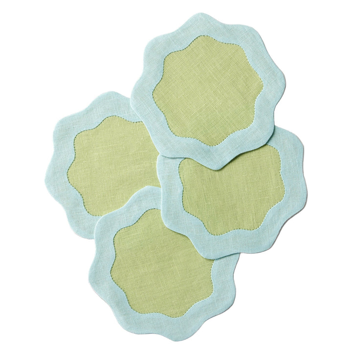 four green coasters with blue wavy edges