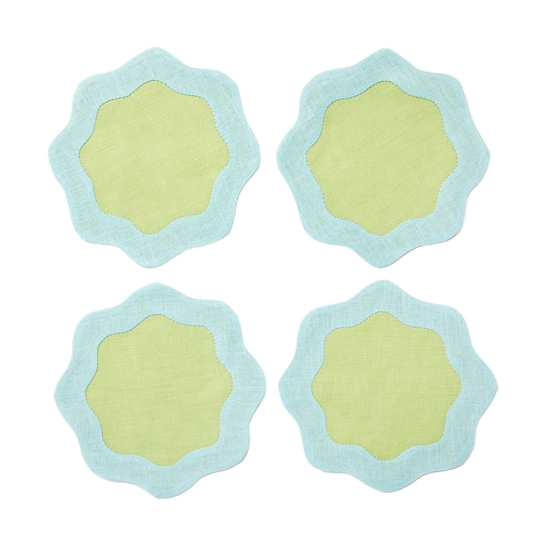 four green coasters with blue wavy edges