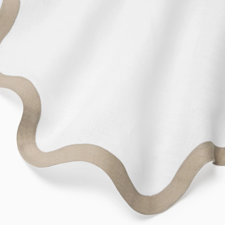 Close-up of a white napkin with a beige border on a white background