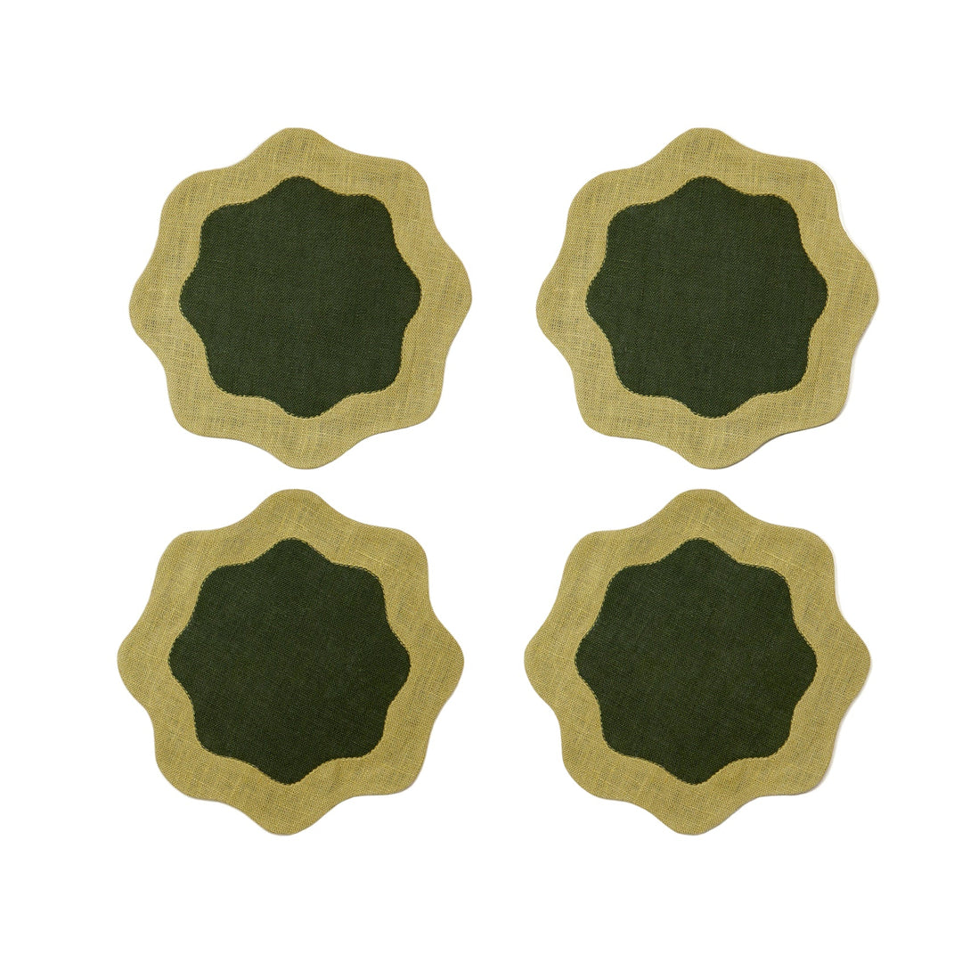 Four green coasters with deeper green centers and wavy edges on a white surface