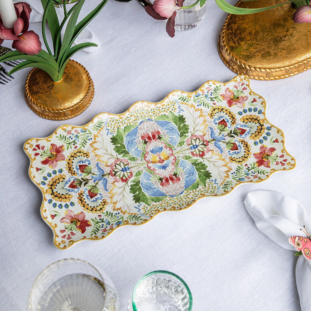 Decorative ceramic platter with floral patterns on a white tablecloth