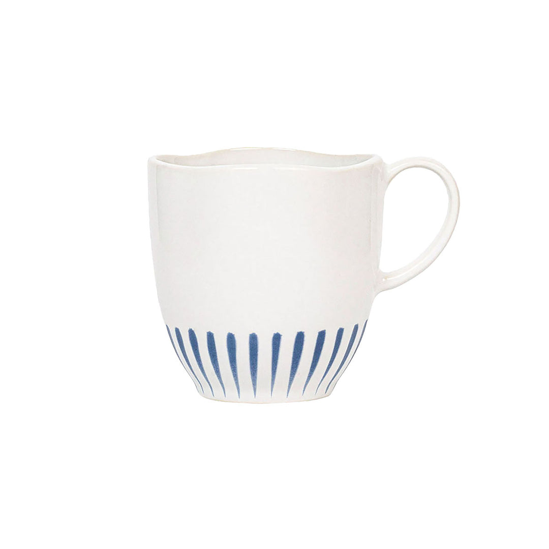 A white mug with blue dotted vertical stripes at toward the base. 