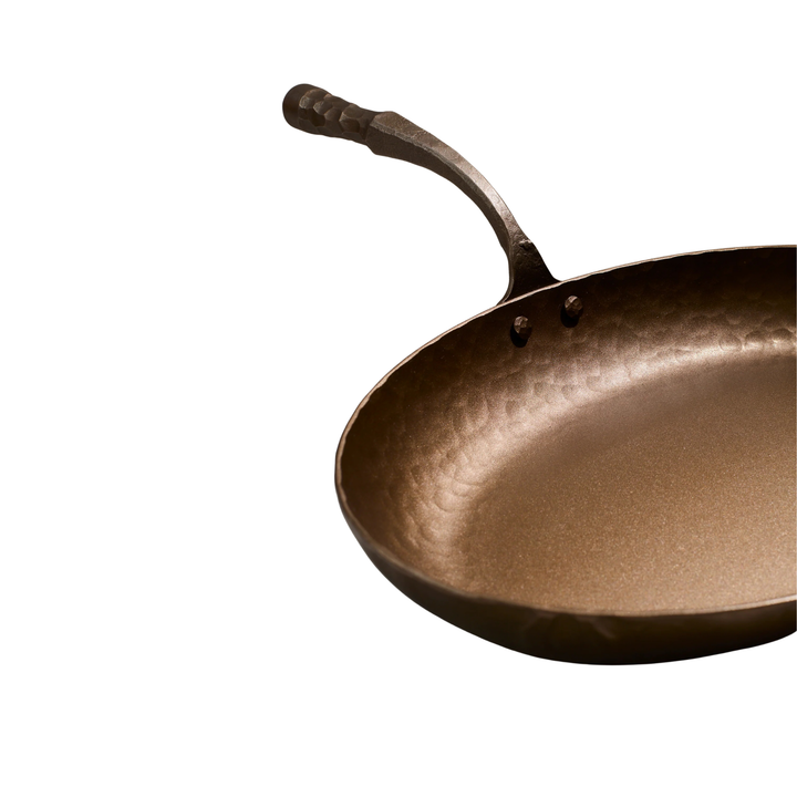 Hammered frying pan on a white background
