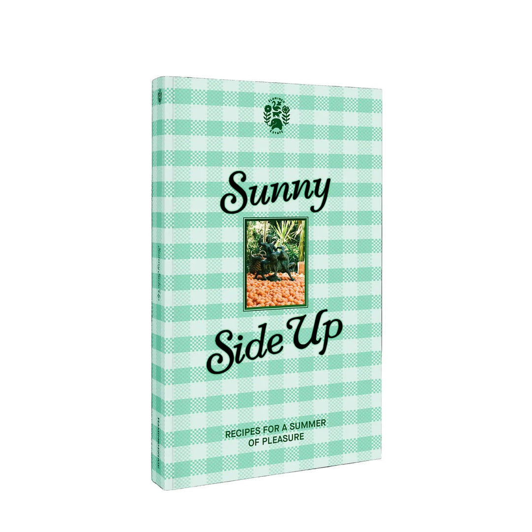 A book titled 'Sunny Side Up' with a mint green and white gingham patterned cover, featuring a small central photograph and the Flamingo estate logo at the top.