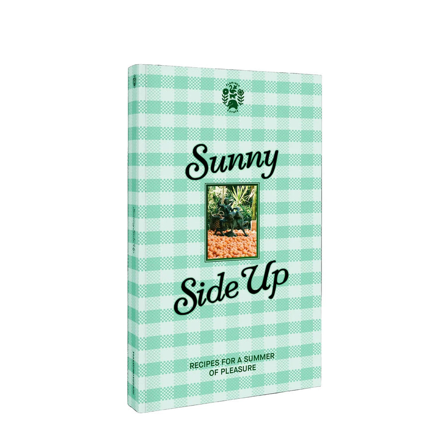 A book titled 'Sunny Side Up' with a mint green and white gingham patterned cover, featuring a small central photograph and the Flamingo estate logo at the top.