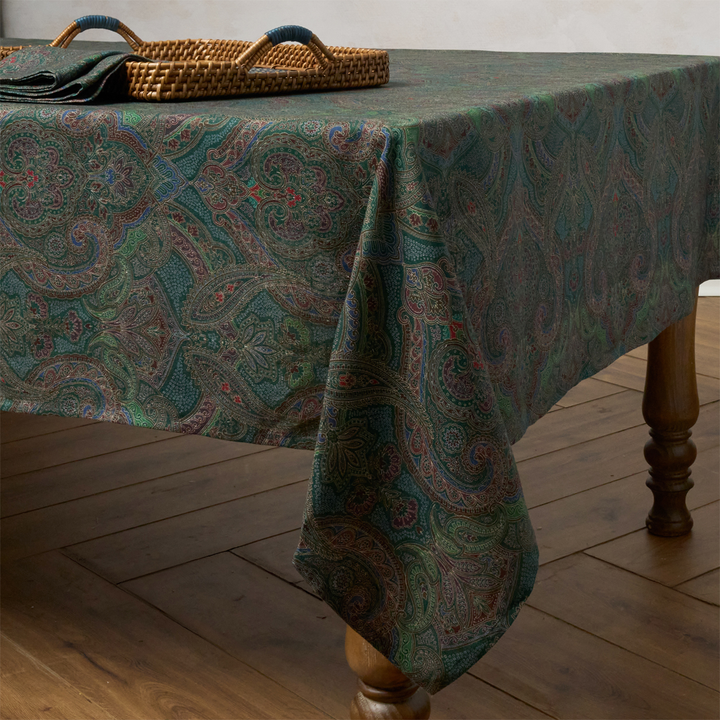 Patterned tablecloth on a wooden table with a wicker basket in the background.