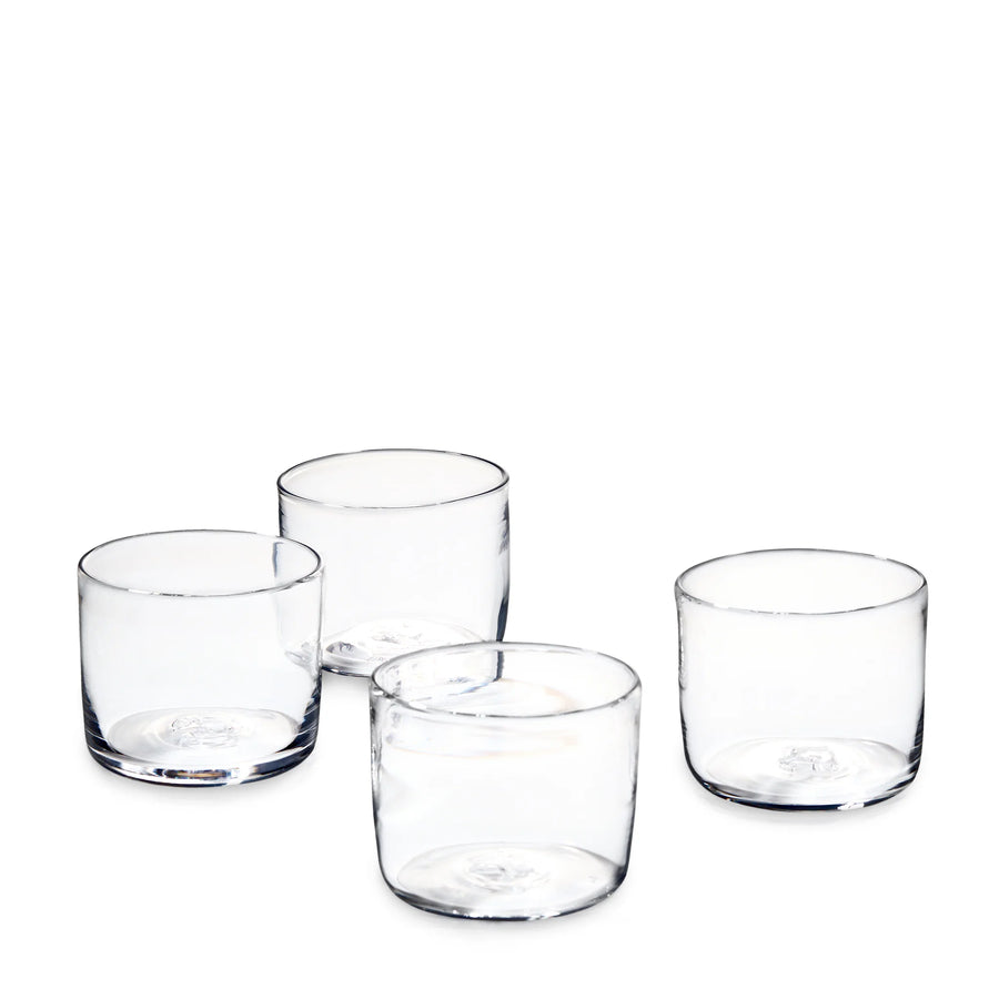 Four clear lowball glasses arranged on a plain white background.