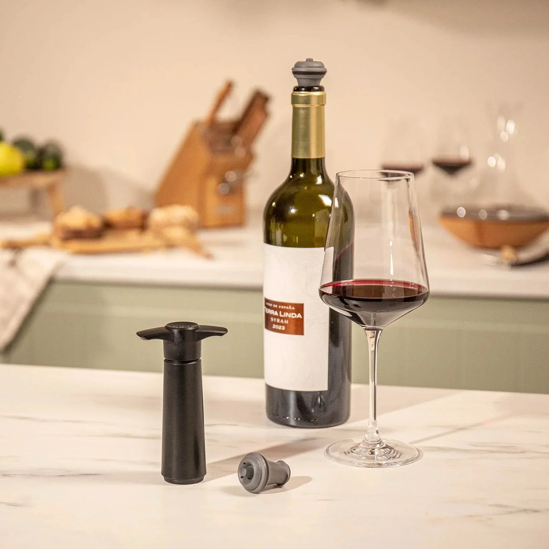 Wine bottle, glass, and wine vacuum pump on a kitchen counter