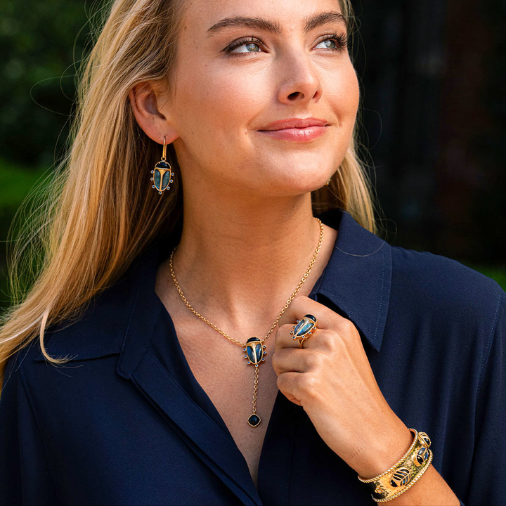 Woman wearing gold jewelry with a dark background